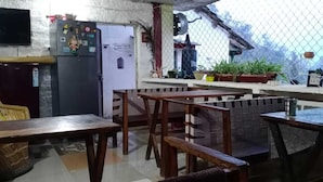 A kitchen with wooden furniture, a refrigerator, and potted plants. - Junegiri Farms & Homestay (Rishikesh)