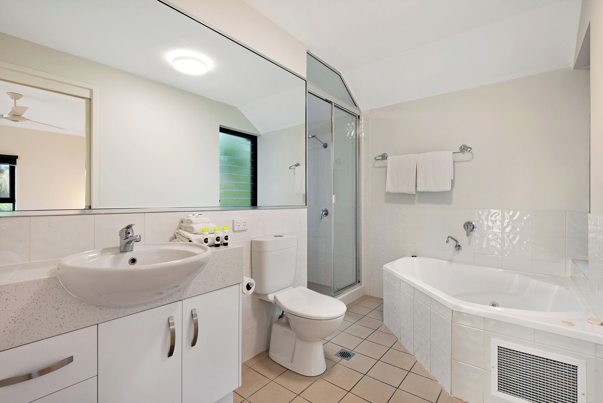 A modern bathroom with a sink, toilet, shower, and bathtub.