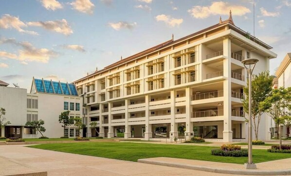 Un edificio de varios pisos con un patio central, balcones y un estilo arquitectónico moderno.