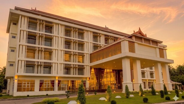 A multi-story hotel with a modern architectural design, featuring a prominent entrance and a well-maintained garden. - Mahachai Grand View (Nakhon Si Thammarat)