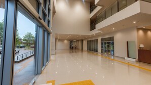 A spacious, modern lobby with a high ceiling, large windows, and a clean, polished floor. - Mahachai Grand View (Nakhon Si Thammarat)