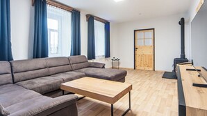 Un salon moderne avec un canapé d’angle, une table basse en bois et une cheminée intégrée.