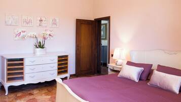 A bedroom with a bed, dresser, and artwork on the wall.