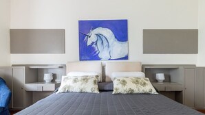 A hotel room with two beds, a large painting of a horse, and a view of the sea. - Beautiful apartment for 6 guests with WIFI, A/C, pool, TV and pets allowed, close to Florence (Impruneta)