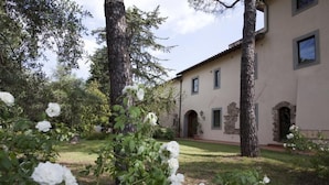 A building with a garden, large trees, and white flowers. - Cosy apartment for 6 guests with pool, WIFI, A/C, TV and pets allowed, close to Florence (Impruneta)