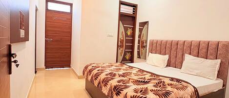 A bedroom with a bed, a ceiling fan, a wardrobe, and a door.