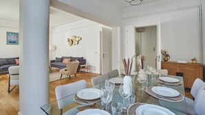 A dining area with a glass table set for six, surrounded by chairs. - Superb apartment Center of Paris-Montmartre (Paris)