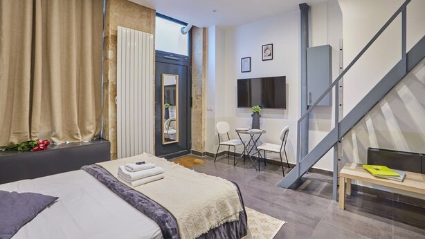 Et moderne hotelværelse med en stor seng, et skrivebord og en trappe.