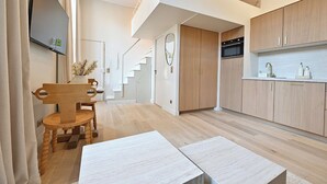 Una cocina moderna con armarios de madera, horno empotrado y encimera blanca.
