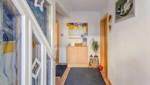 Ein Flur mit einem Holzschrank, einem Korkbrett und einem gerahmten Bild an der Wand.