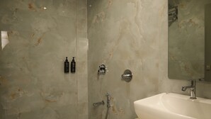 A modern bathroom with a marble wall, a sink, a toilet, and a shower. - Adkar Residency Gorai Borivali West  (Mumbai)