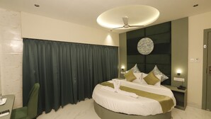 A modern hotel room with a round bed, a desk, and a chair. - Adkar Residency Gorai Borivali West  (Mumbai)