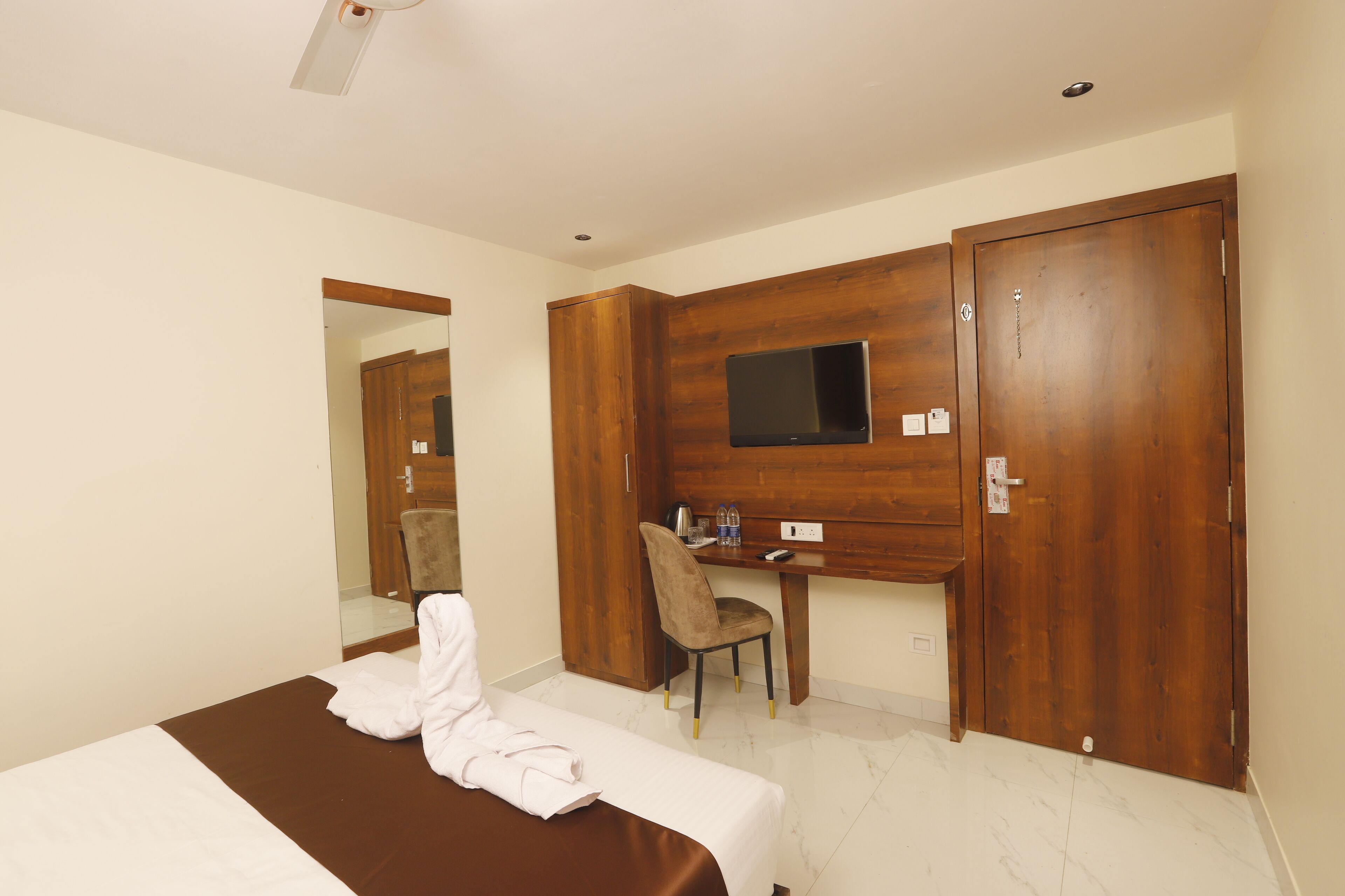 Une chambre d’hôtel comprenant un lit, un bureau, une chaise et une armoire.
