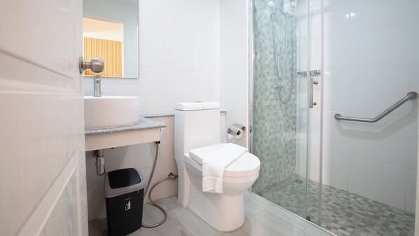 A modern bathroom with a toilet, sink, and glass shower enclosure. - B2 Khao Yai Premier Hotel (Pak Chong)