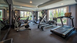 Un gimnasio con cintas de correr, elípticas y equipo de pesas.
