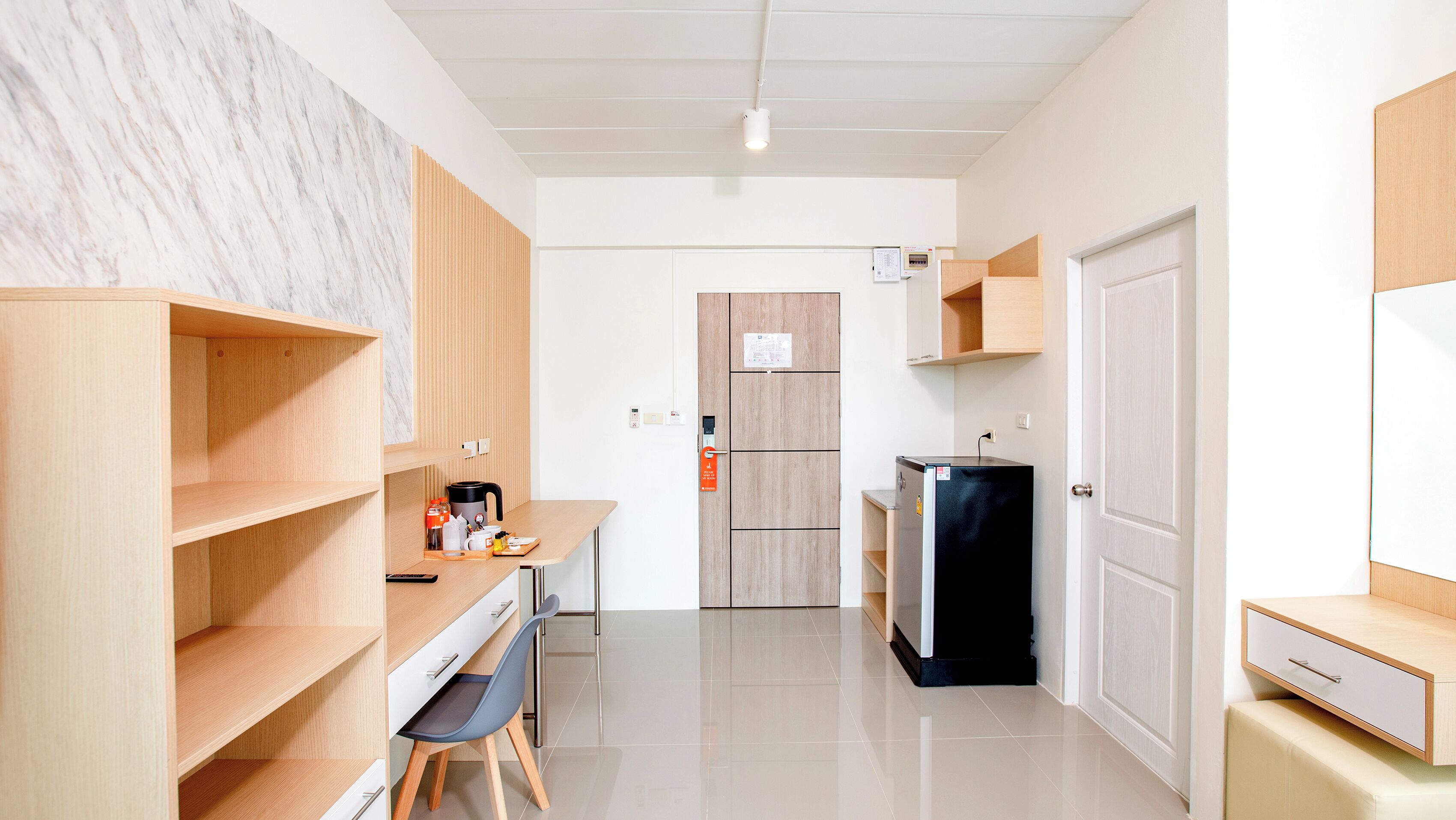 A modern kitchen with wooden cabinets, a black refrigerator, and a coffee machine.