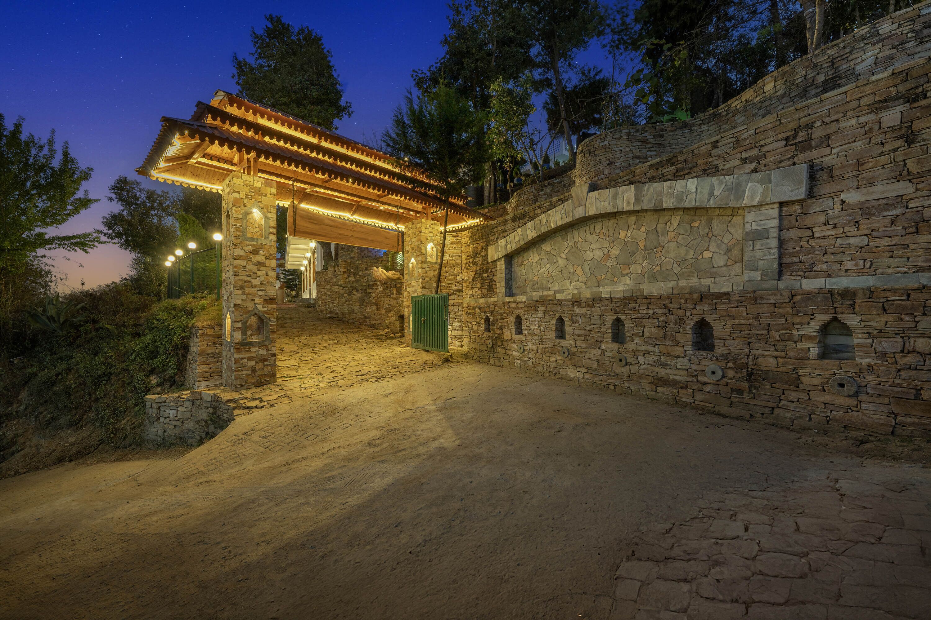Un edificio de piedra con un porche cubierto y una pared de piedra con ventanas de arco.