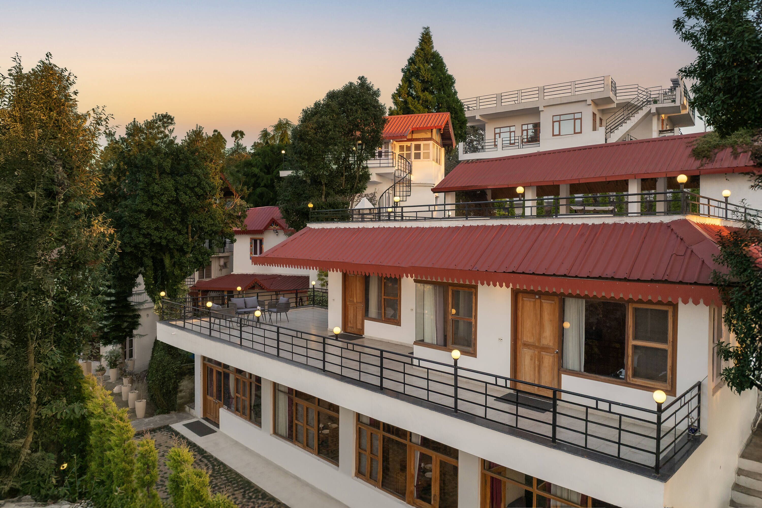 A multi-story building with a red roof, balconies, and large windows.