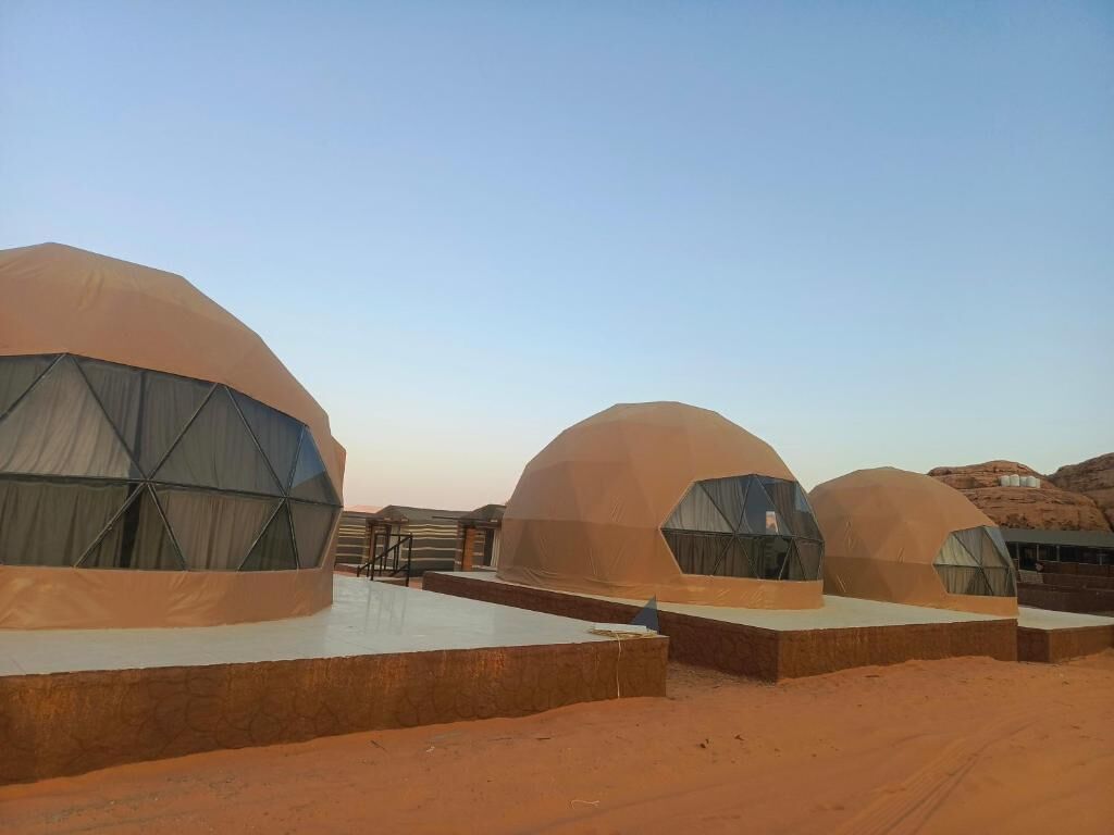 A desert landscape with multiple dome-shaped tents.