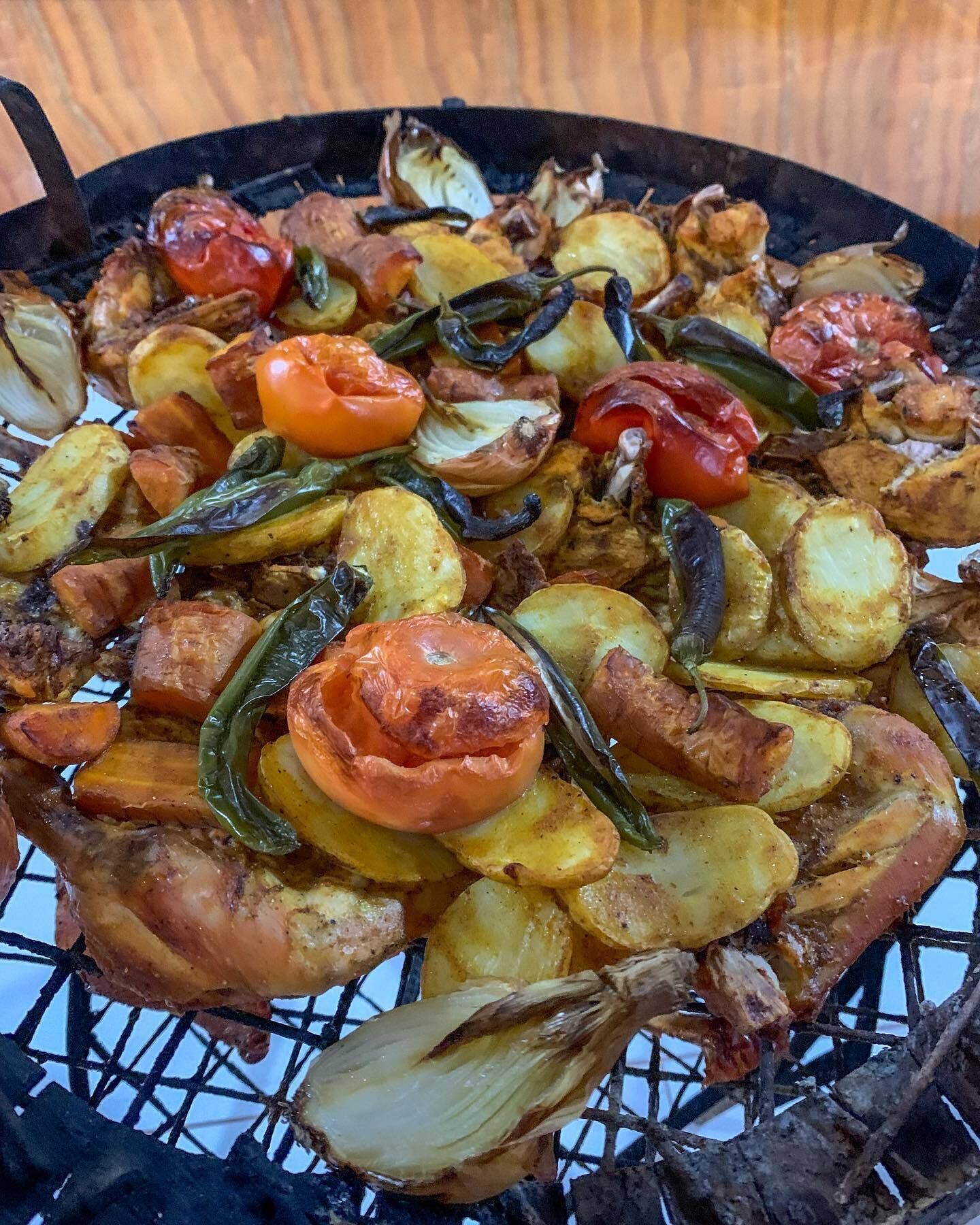 Ein Grill mit verschiedenen Gemüsesorten und Fleisch, das zubereitet wird.
