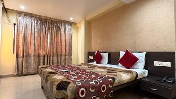 A hotel room with a bed, a nightstand, a telephone, and a ceiling fan.
