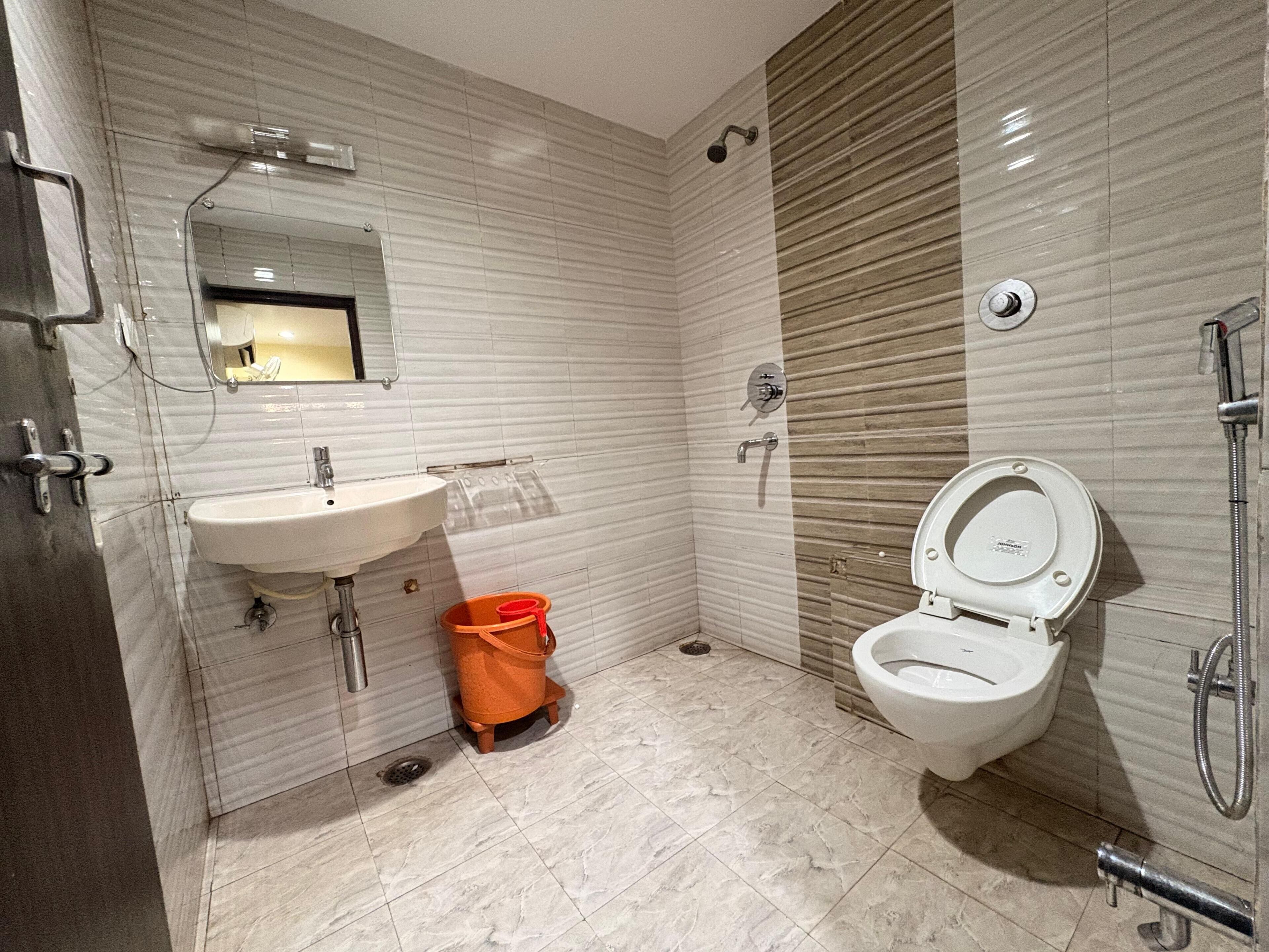 Un baño moderno con lavamanos blanco, inodoro y ducha.