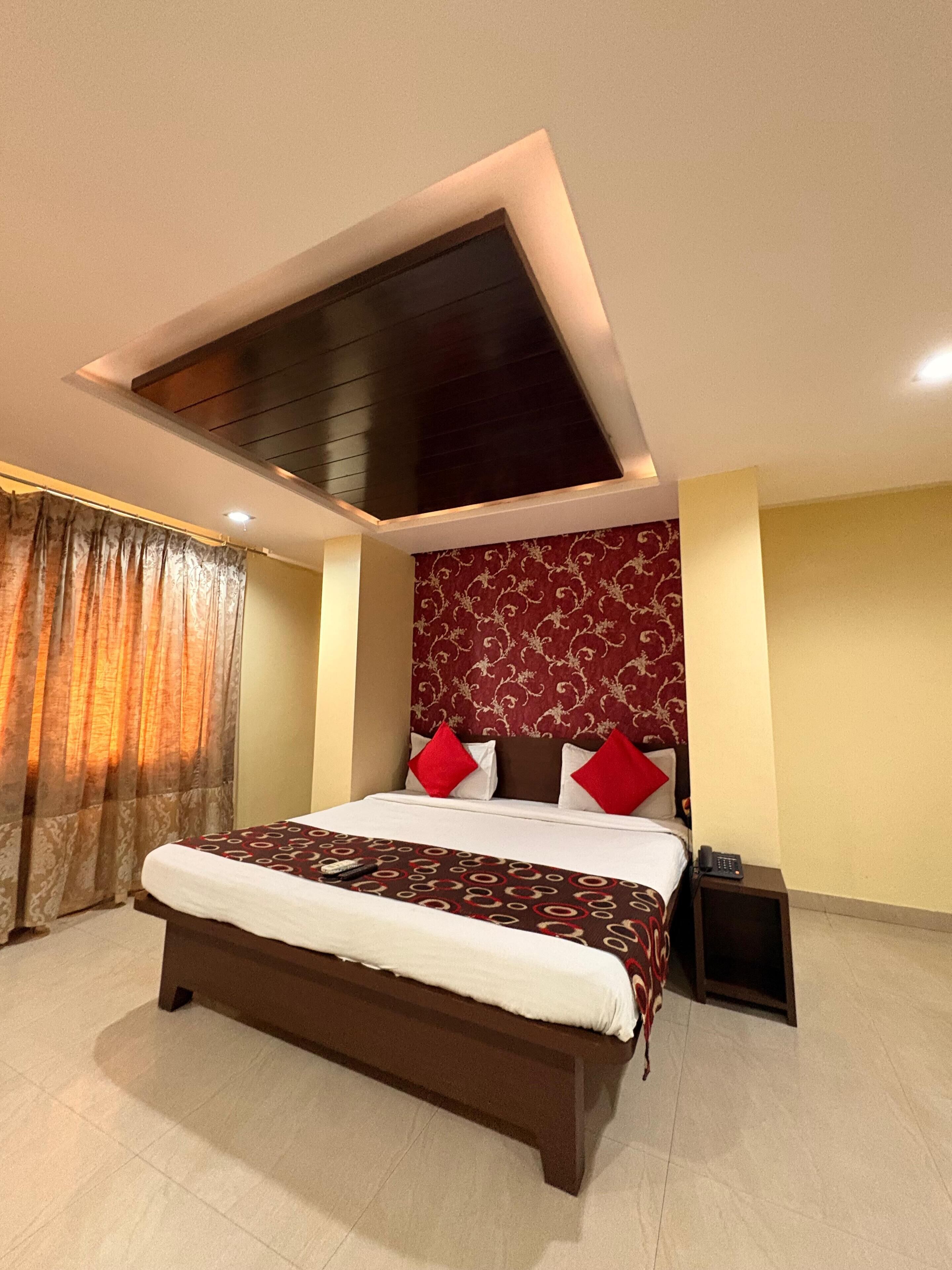 Een moderne hotelkamer met een groot bed, dakraam en een behang met patroon.