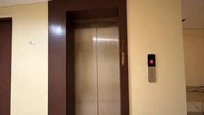 An elevator with a digital display, a welcome mat, and a plain wall with a door frame. - Hotel Welfare Club (Bhilai)