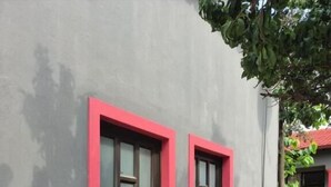 A building with two windows, each with a red frame and a dark shutter. - DreamWest Living Guesthouse  (Krugersdorp)