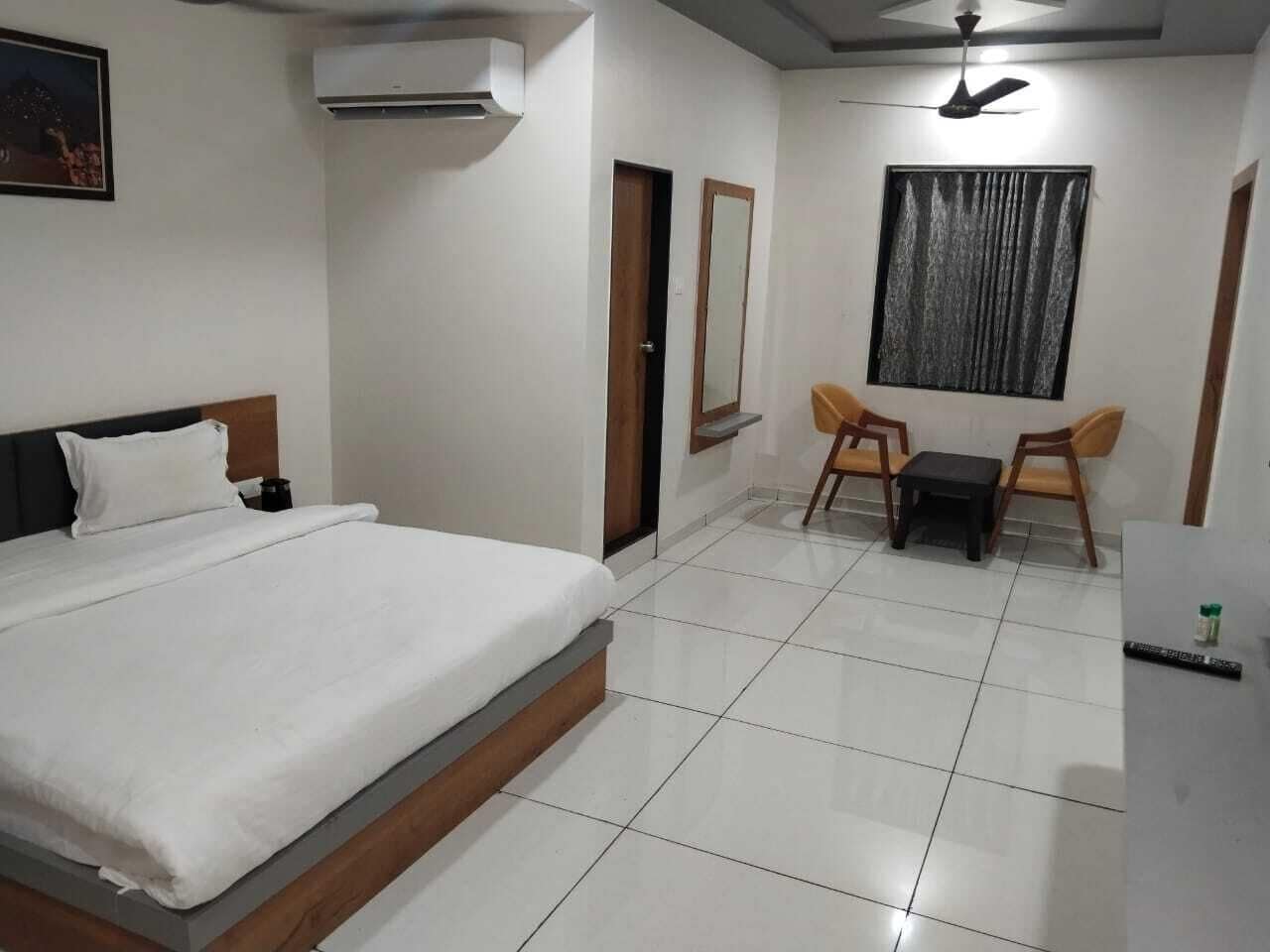 Una habitación de hotel con una cama, un escritorio, una silla y una pequeña mesa.