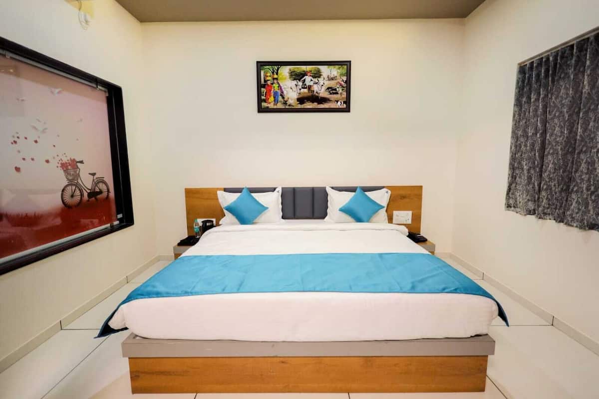 A neatly made bed with a blue and white bedspread, a wooden headboard, and a framed picture above it.