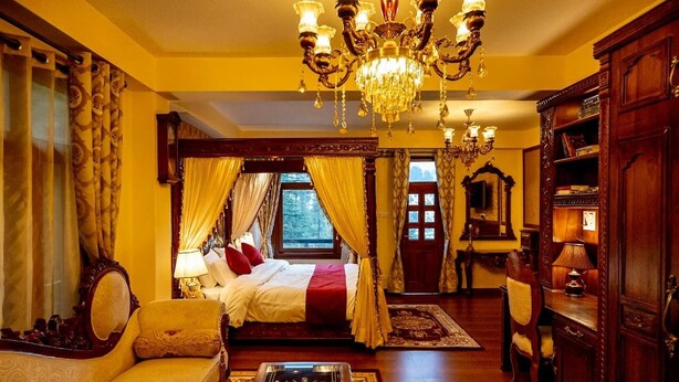 A traditional bedroom with a four-poster bed, a chandelier, and a view of the outdoors. - The Himalayan Heritage (Shimla)