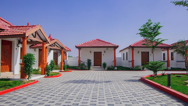 Un patio con un camino empedrado, rodeado de edificios con tejados rojos y paredes blancas.