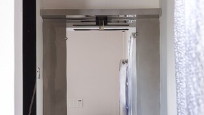 Habitación compacta y moderna con armario empotrado, una pequeña mesa y un espejo.