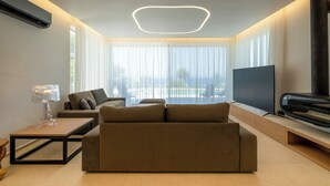 Uma sala de estar moderna com um sofá, uma TV de tela plana e uma lareira.