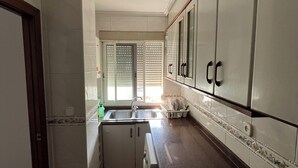 Una cocina con un lavaplatos, armarios y lavavajillas.