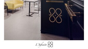 A modern hotel room with a piano, a yellow sofa, a dining area, and a large mirror. - L'Infinito88 Charmant rooms (Naples)