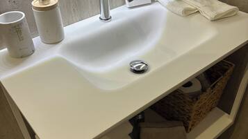 Een douche, een haardroger, pantoffels, handdoeken