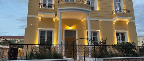 A two-story building with a yellow facade, multiple windows, and balconies.