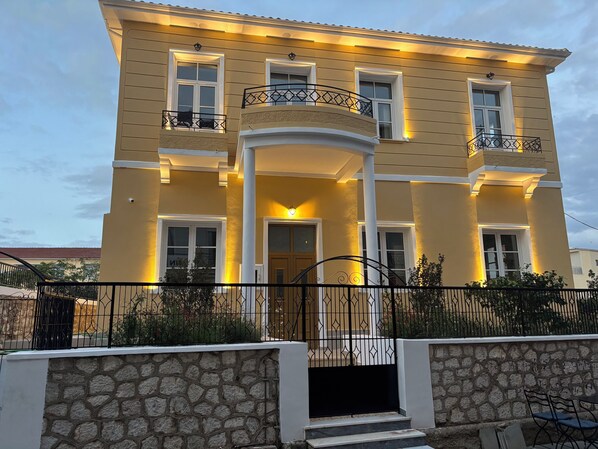 A two-story building with a yellow facade, multiple windows, and balconies. - Maissance (Preveza)