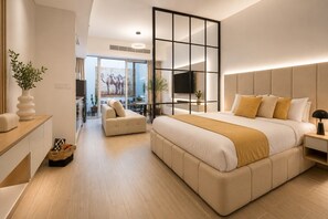 Une chambre d’hôtel moderne avec un grand lit, un canapé, une télévision et une grande fenêtre.
