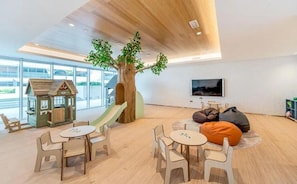 A children's play area with a slide, playhouse, and seating.