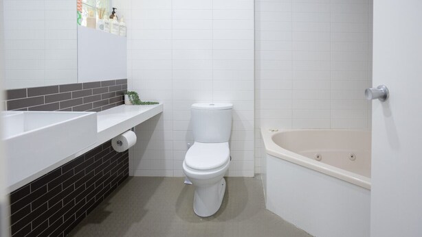 A bathroom with a toilet, a sink, and a bathtub. - Bay View - The Trio (Lorne)