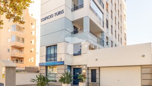 A modern building with a sign reading "EDIFICIO TURIS." It features balconies, a garage door, and potted plants in the foreground. - CostaBlancaDreams - Apartment Turis in Calpe (Calpe)