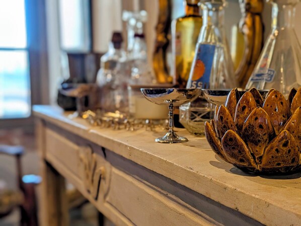Un espace bar avec différentes bouteilles et différents verres disposés sur un comptoir.