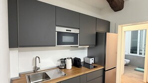 A modern kitchen with dark cabinets, stainless steel appliances, and a wooden countertop. - Adriano Space, a complete and functional apartment in the center of Modena (Modena)