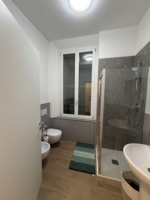 A modern bathroom with a toilet, bidet, and shower. - Adriano Space, a complete and functional apartment in the center of Modena (Modena)
