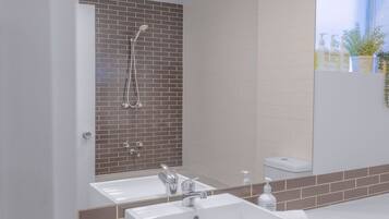 A bathroom with a shower, two sinks, and a mirror.