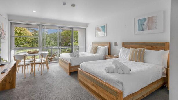 A modern bedroom with two beds, a desk, and a chair. - Bay View: Ocean Breeze (Lorne)