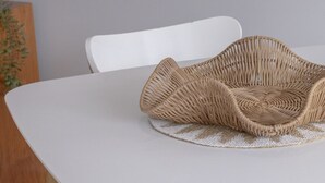 A white table with a woven placemat and a white chair with wooden legs. - Bay View: Ocean Breeze (Lorne)